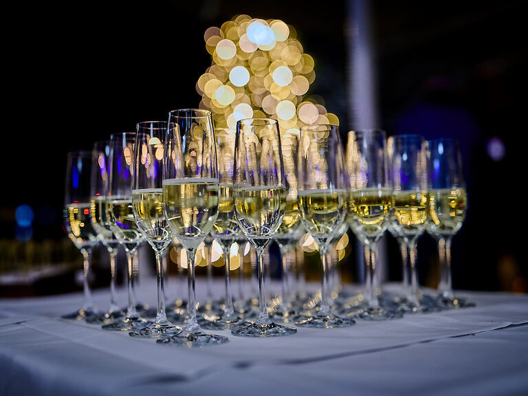Im Toni´s stehen volle Sektgläser auf einem Tisch in dunkler Umgebung.
